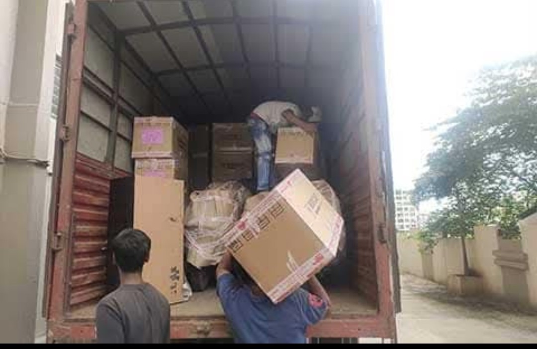 Moving team loading packed boxes into a truck